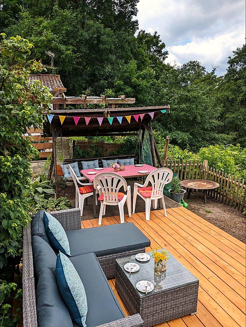 Überdachte Sitzecke mit Wimpelkette im Garten