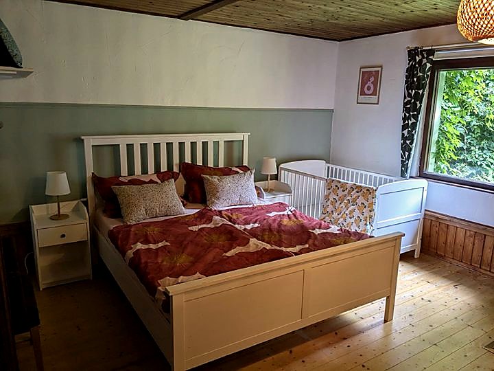 Schlafzimmer mit Doppelbett und Babybett